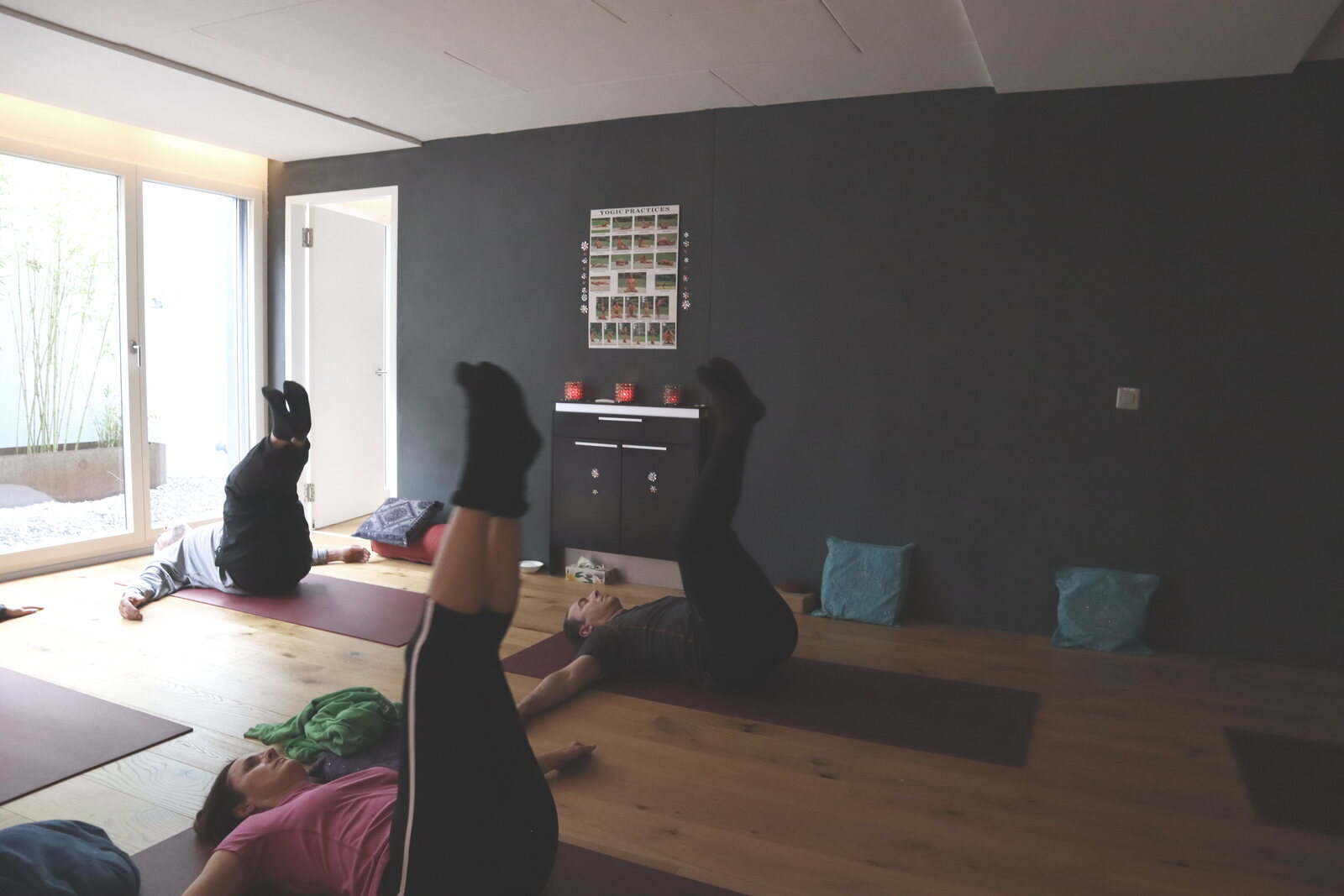 Teilnehmende üben den Pflug im Yogastudio