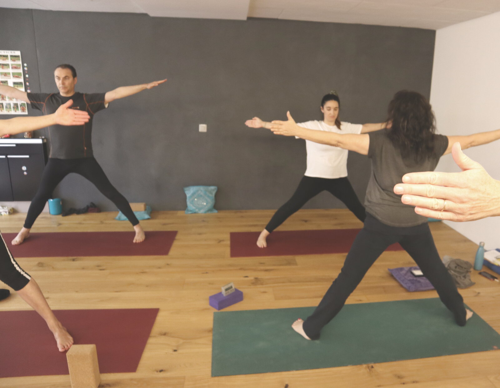 Gruppe übt im Yogastudio den Krieger II