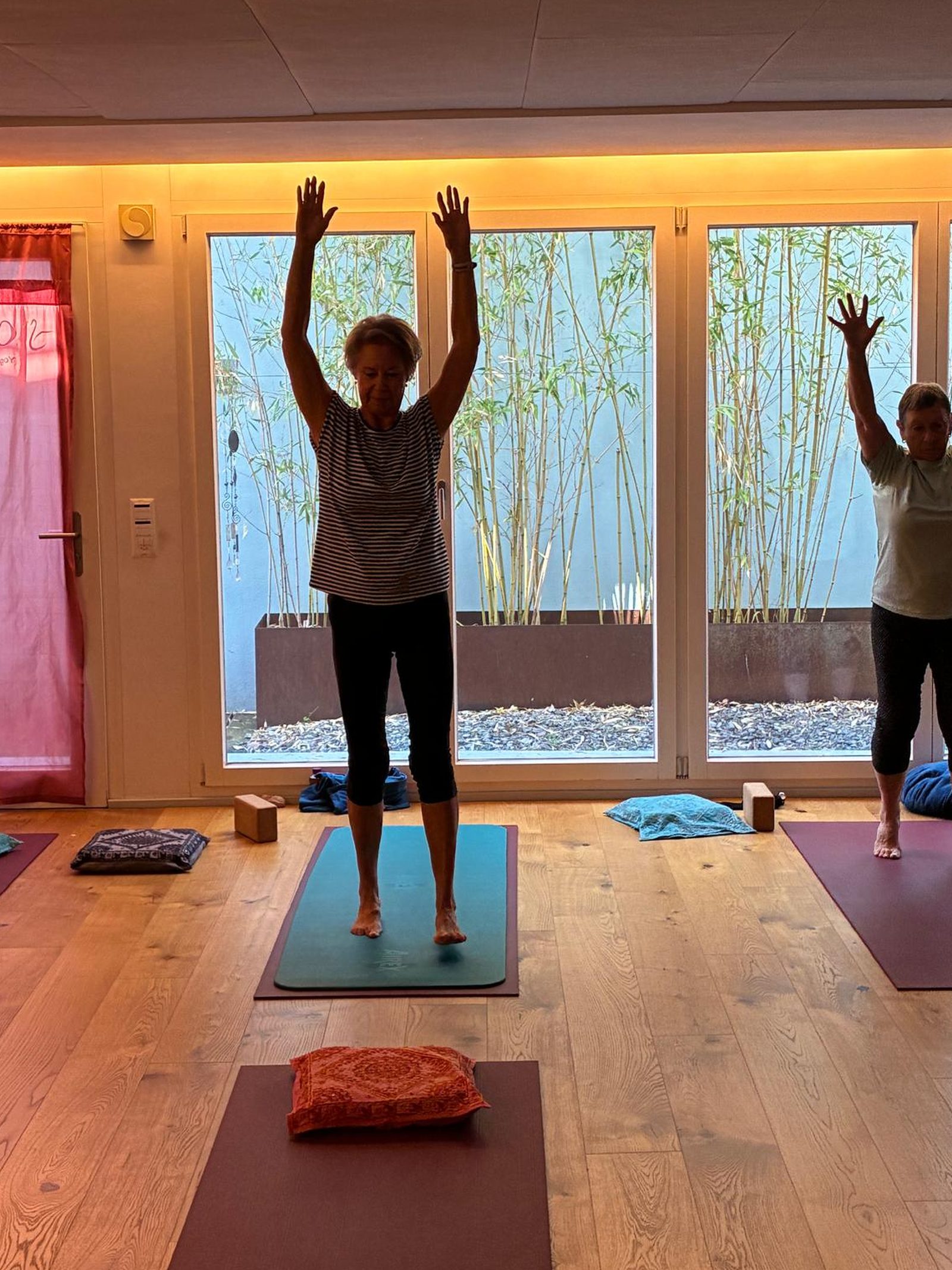 Teilnehmerin hebt im Studio Soham Yoga beide Arme über den Kopf