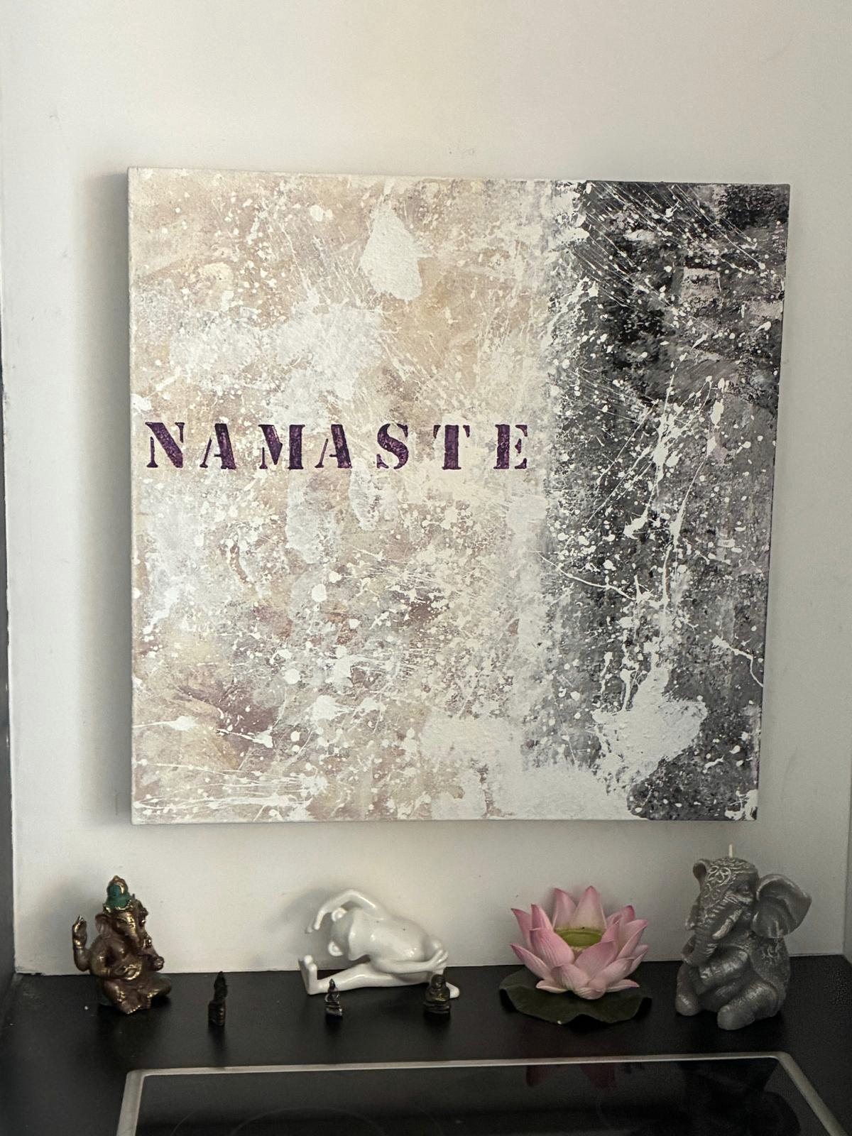 Bild mit dem Schriftzug Namaste über einer Ablage mit Ganesha-Figuren und einer Lotusblüte